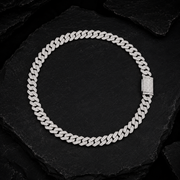 Iced Out Moissanite Cuban Link Chain on Black Stone Surface